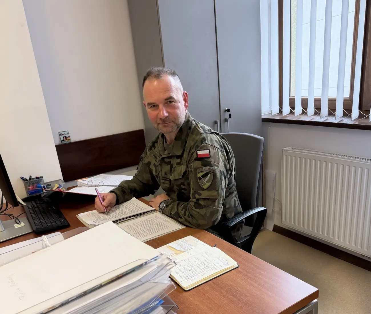 Urzędnik w mundurze przy biurku, o co chodzi w tej inicjatywie?